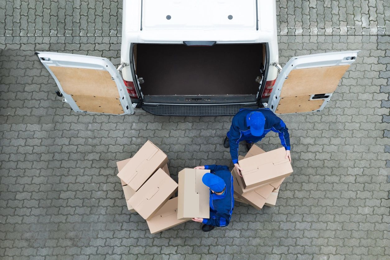 Directly above shot of delivery men unloading cardboard boxes from truck on street